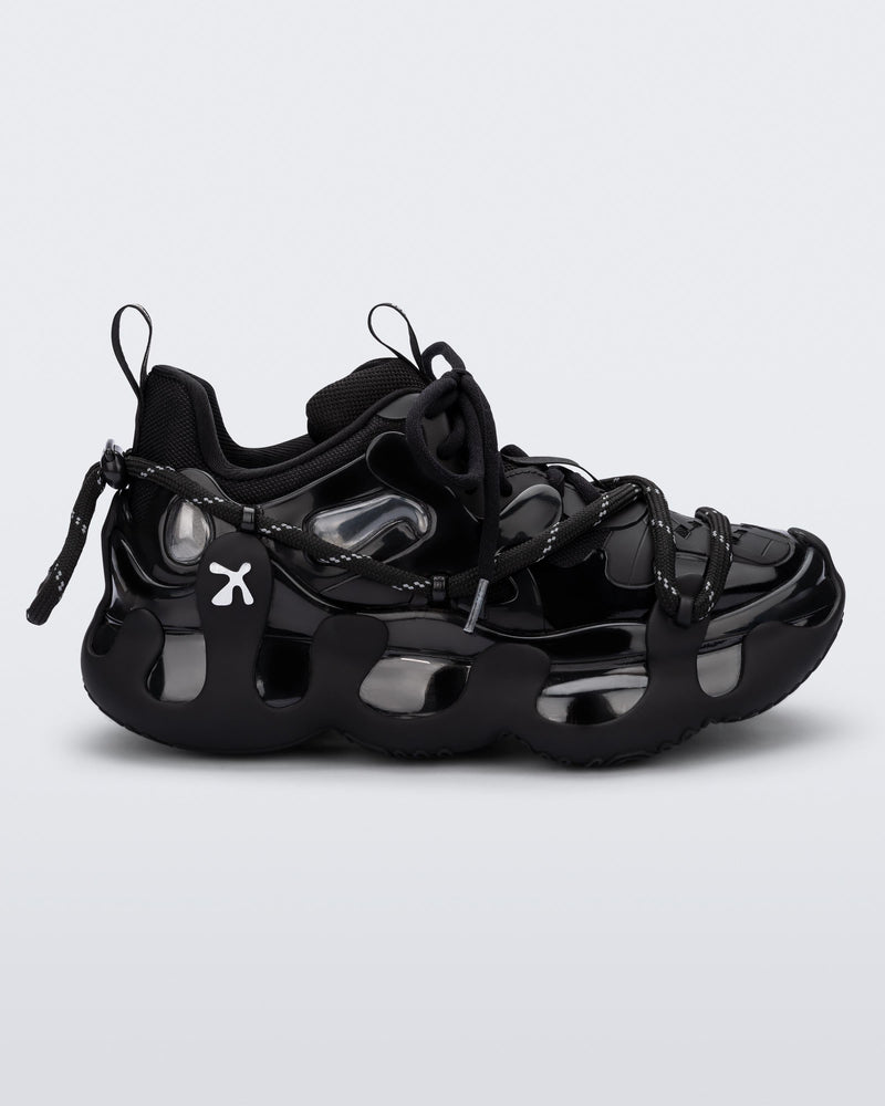 Side view of a black with grey accents Melissa X Icon sneaker