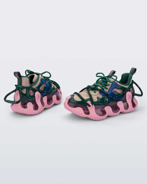 Side and back view of a pair of Melissa X Icon sneaker with pink sole and green and blue accents