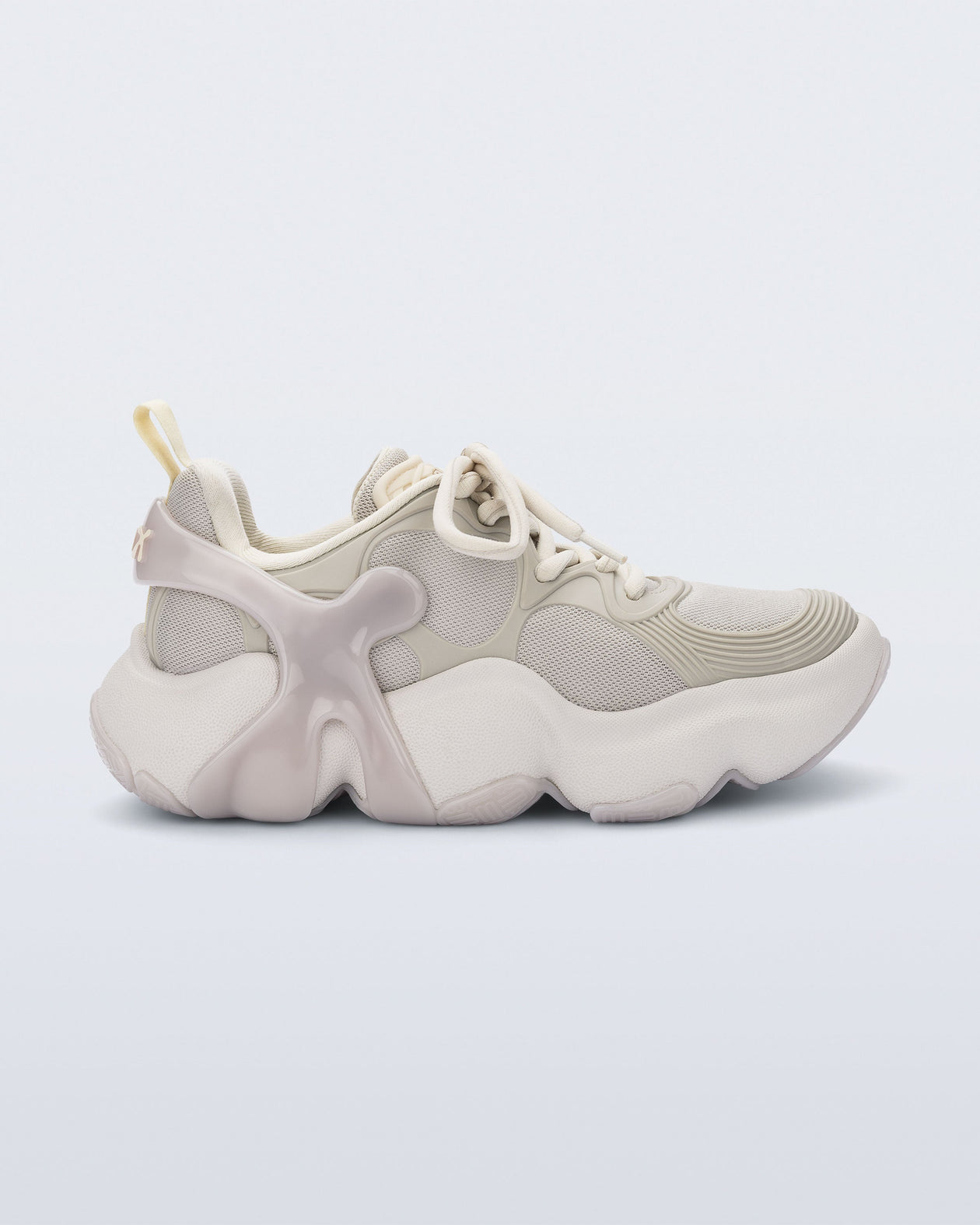 Side view of a Beige Melissa X Rush sneaker