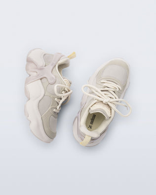 Side and top view of a pair of beige Melissa X Rush sneakers