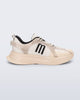 Side view of a Beige Melissa X Beat sneaker with black logo on a light gray background