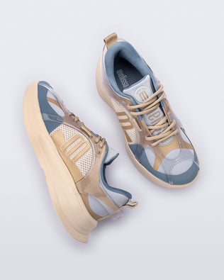 Top and side angled view of a pair of beige and gray Melissa X sneakers on a light gray background