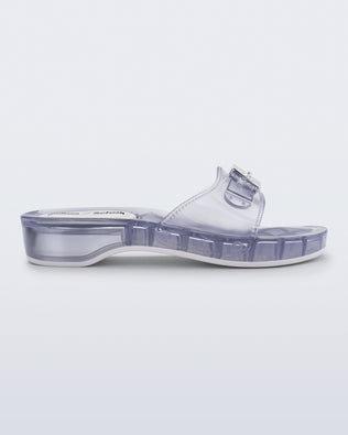 Side view of a clear Pescura Heel + Scholl slide with top buckle