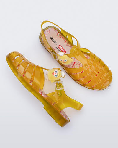 Top view of a pair of transparent yellow Possession + Pop Mart Pucky fisherman sandals