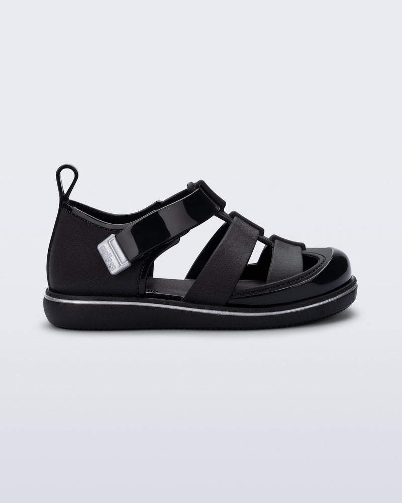 Side view of a black Smash closed toe baby sandal with grey trim
