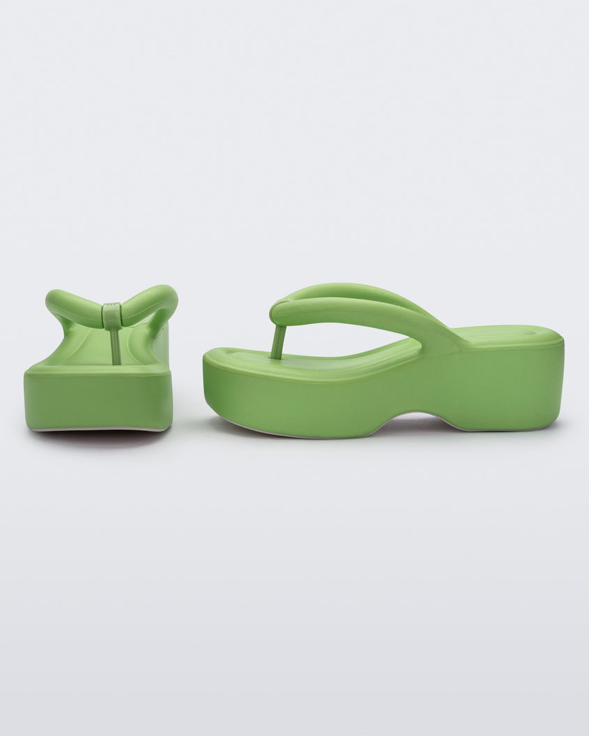 Front and side view of a pair of Melissa Free platform flip flops in lime green with grey soles