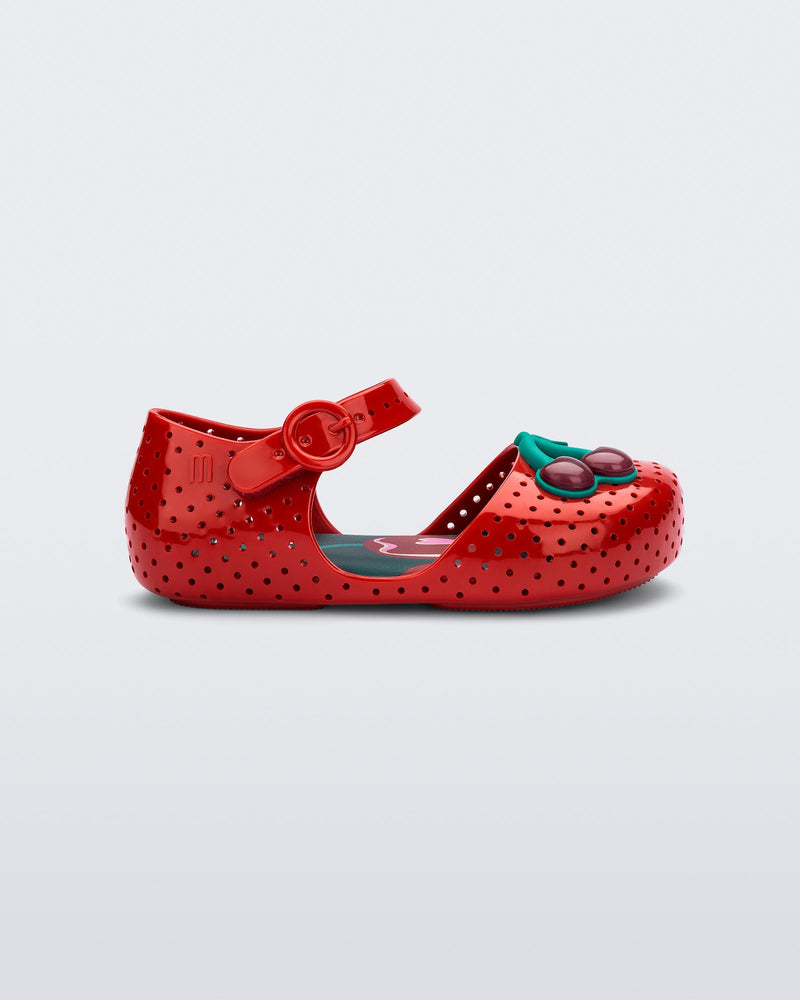 Side view of a red Pop baby flat with two dark red cherries
