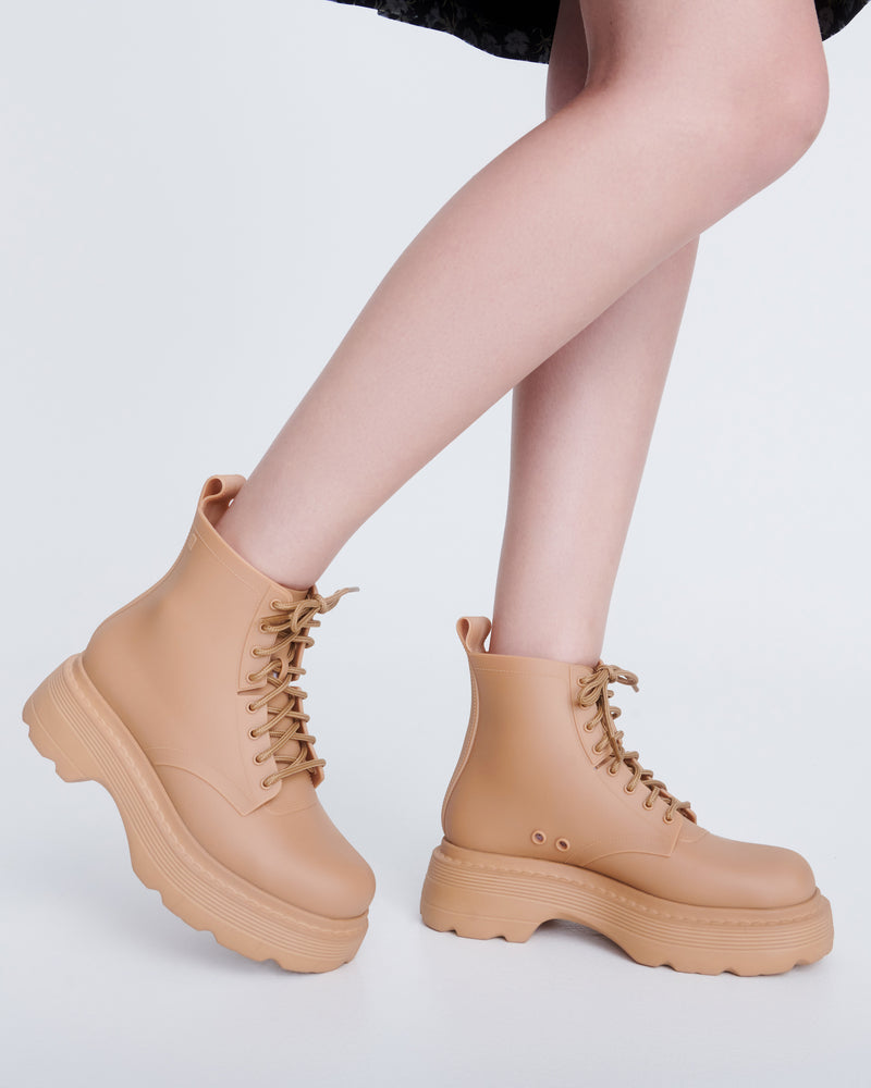 Model's legs wearing a pair of matte beige Coturno Soft Platform boots