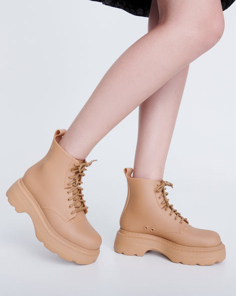 Model's legs wearing a pair of matte beige Coturno Soft Platform boots