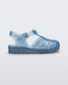 Side view of a Mini Melissa Possession baby sandal in glitter blue with velcro buckle closure on the ankle strap