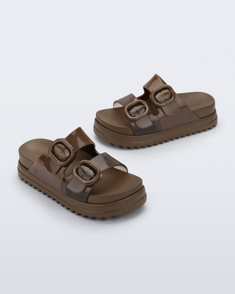 Side and angled view of a pair of brown Cozy Platform kids slides with two straps with buckles, one clear brown