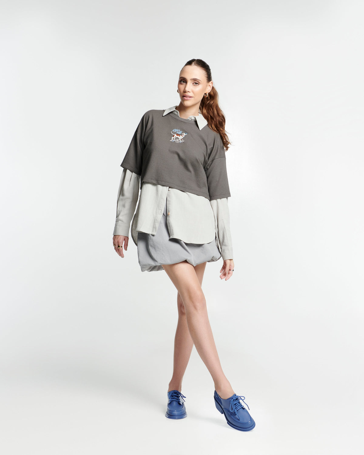 Model in a beige outfit wearing a pair of blue Tailor loafers