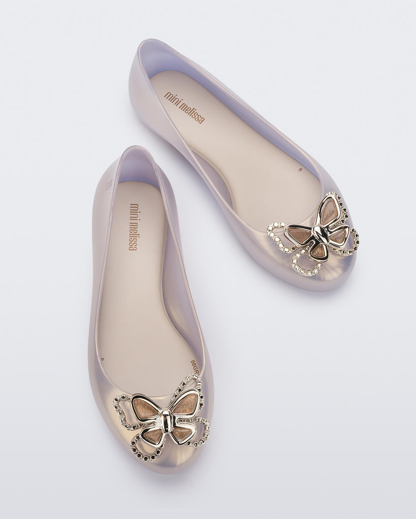 Top view of a pair of pearly gold Mini Melissa Sweet Love Butterfly flats with a gold butterfly detail on the toe