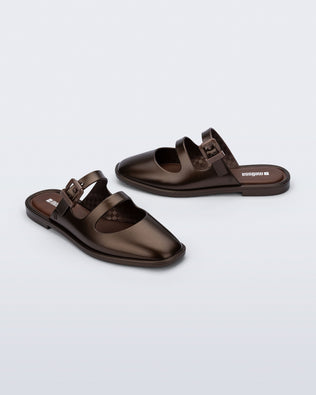 Side and angled view of a pair of bronze Anastasia mule slides