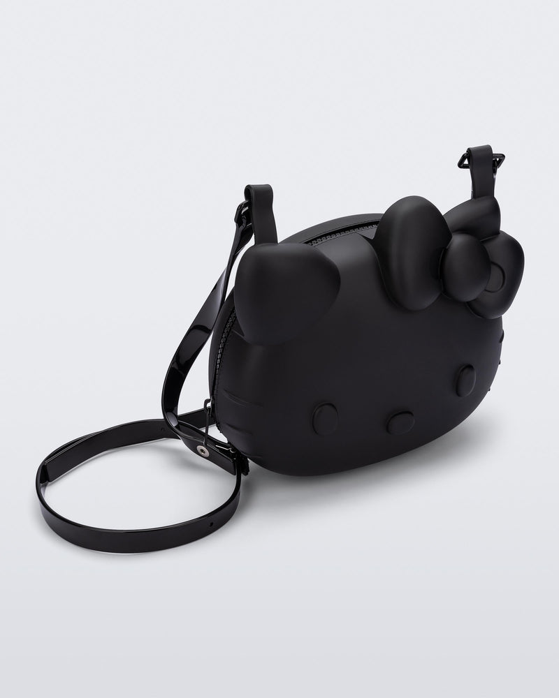 Angled view of a black Hello Kitty + Friends Cute Bag with the face of Hello Kitty