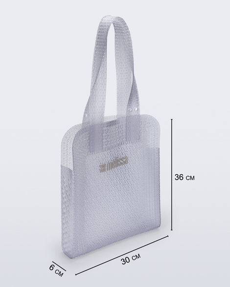 Angled view of a clear Harper bag with shoulder straps with bag measurements of 30cm x 6cm x 36cm
