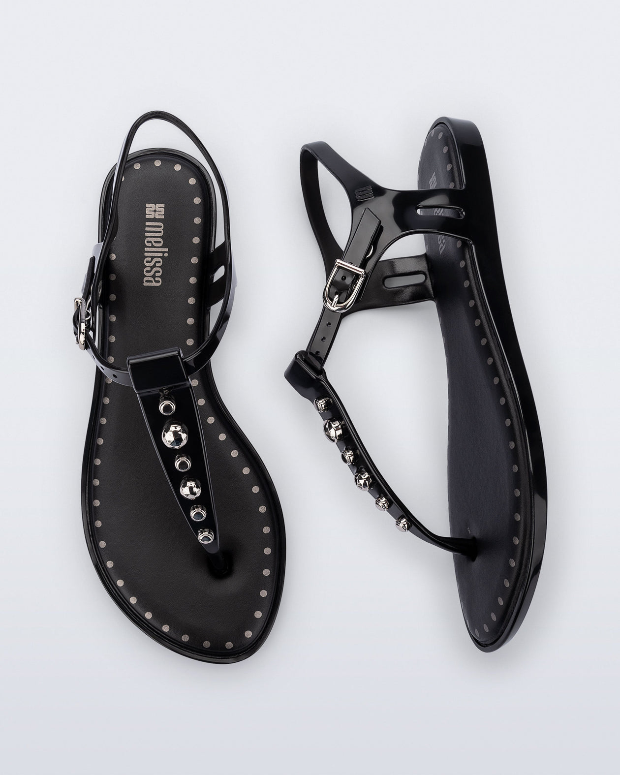 Top and Side view of a pair of black Solar Boho t-strap sandals with ,metallic detailing on the front strap