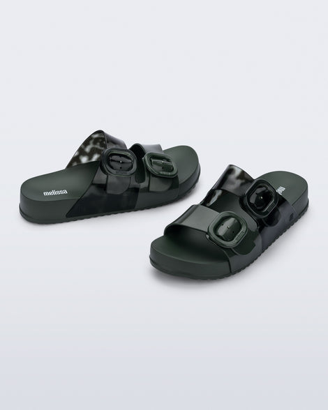 Side and angled view of a pair of dark green Cozy slides with part clear green upper with 2 buckles