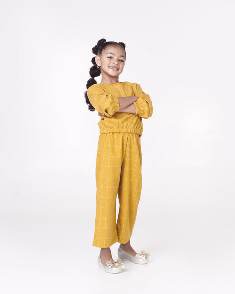 Model posing in a yellow top/pant set wearing pair of Mini Melissa Ultragirl peeptoe ballet flats in white with star printed butterfly bow applique. 