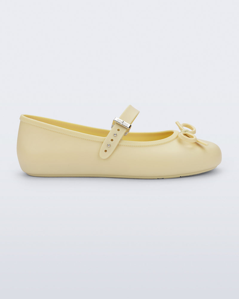 Side view of a yellow Soft Ballerina Delicate Bow flat with top strap and bow