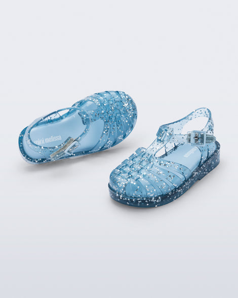 Top and angled view of a pair of blue Possession Elements baby sandal with glitter hearts