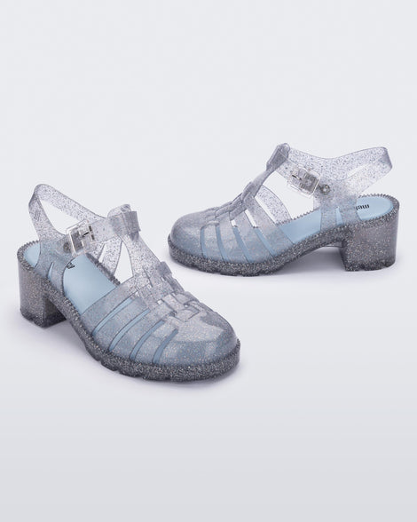 Angled view of a pair of clear glitter Possession Heel women's fisherman style sandals.