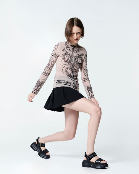 Model in a black skirt and cream top wearing a pair of black Pulse platform sandals with straps
