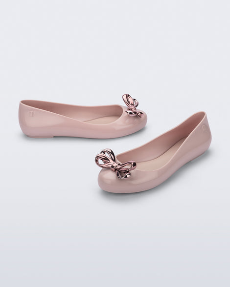 Side and angled view of a pair of pink Sweet Love Glam ballerina flats with pink chrome bow