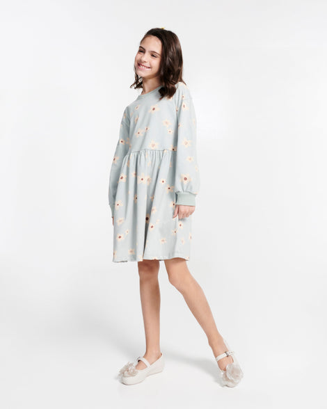 Child model in a blue dress wearing a pair of beige Soft Ballerina Petals kids flats