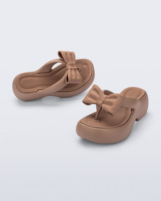 Side and angled view of a pair of brown Free Fuzzy Platform flip flops