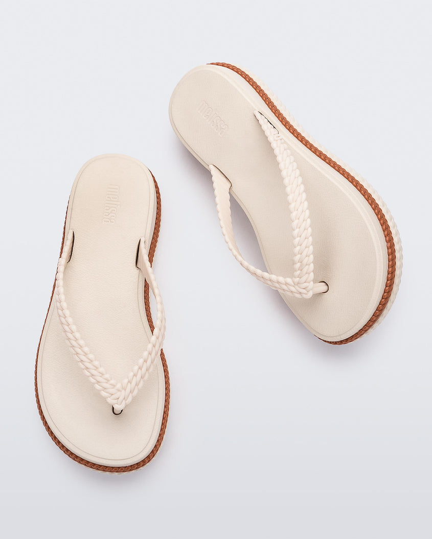 Top view of a pair of beige/brown Melissa Leblon platform flip flops with details that mimic sisal braids on the sole and strap