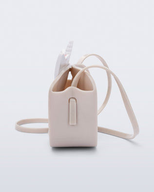 Side  view of a beige Dreamy Unicorn kids bag with a unicorn face on front with pink hair