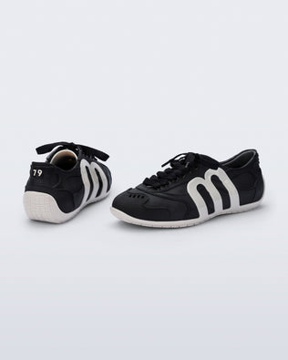 Back and side view of a pair of black Motion sneakers with white colored sole and M monogram on side and 79 on heel