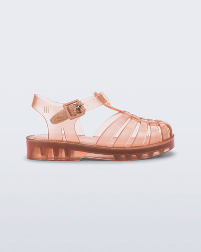 Side view of a clear beige/pink Possession baby sandal