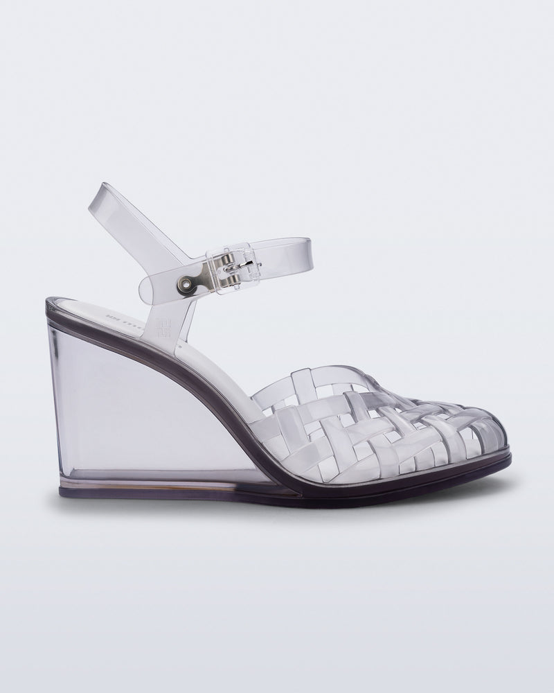 Side view of a clear grey Agata wedge heel sandal with ankle strap