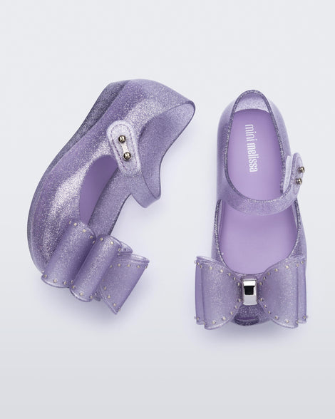 Top and side view of a pair of glitter lilac Ultragirl Classic bow baby flats