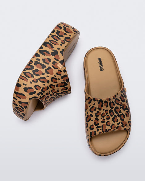 Side and top view of a pair of beige Free Print Platform slides with a brown and black leopard print.
