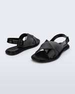 Back and angled view of a pair of black Cleo sandals with back strap and crisscross top straps