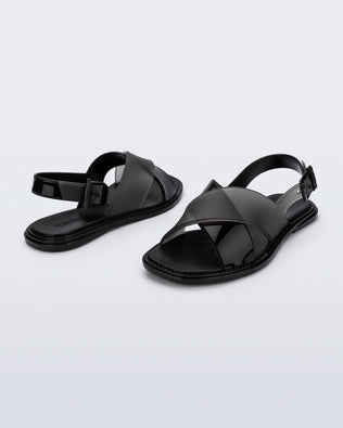 Back and angled view of a pair of black Cleo sandals with back strap and crisscross top straps