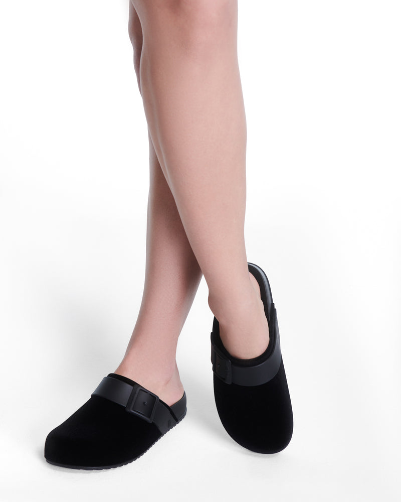 Model's legs wearing a pair of black Cozy Clog Velvet slides