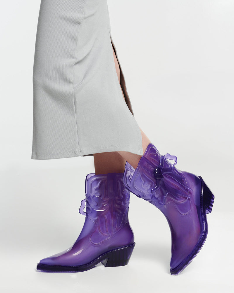 Model's legs in a pair of transparent purple Texas + Maldito boots