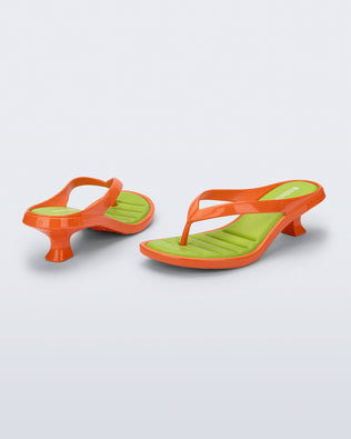 Back and angled view of a pair of orange Flip Flop Kitten Heels with green insole