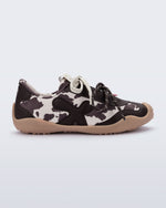 Side view of a black and white cow print X Bend sneaker with beige sole