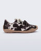 Side view of a black and white cow print X Bend sneaker with beige sole