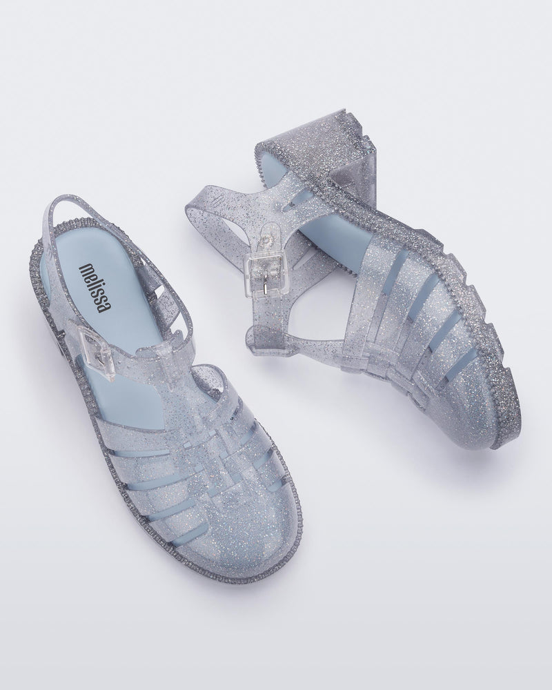 Side and top view of a pair of clear glitter Possession Heel women's fisherman style sandals.