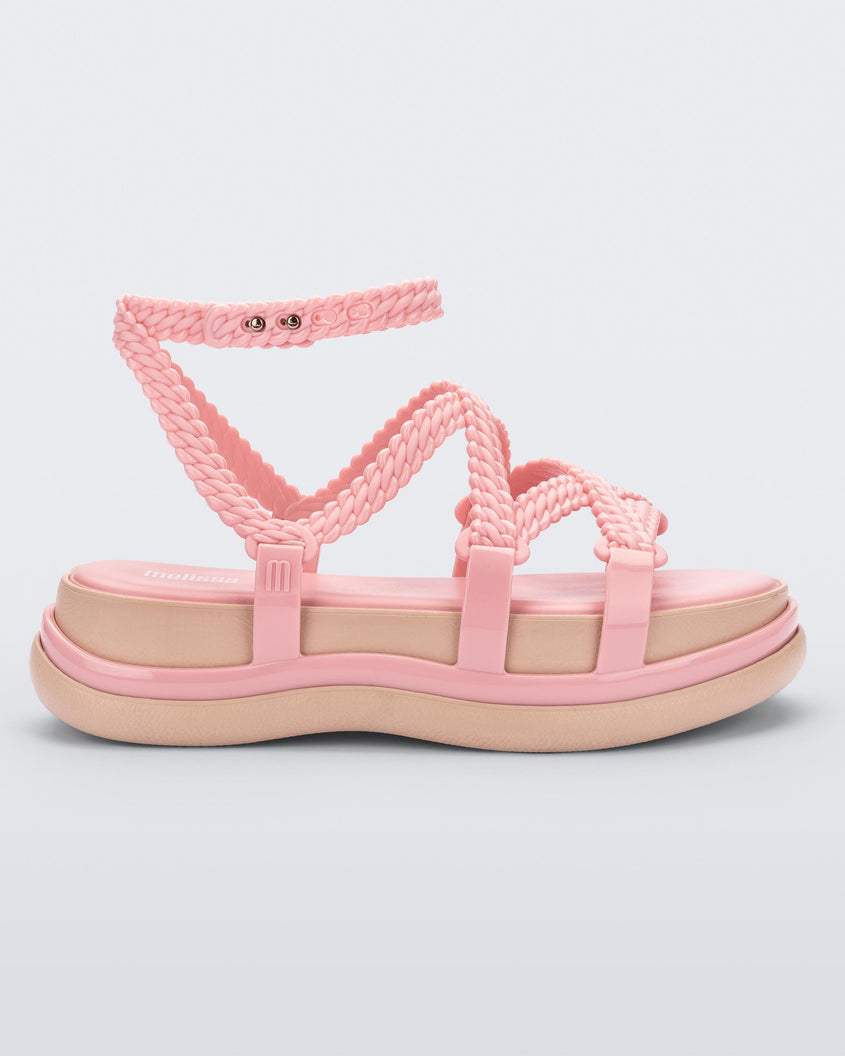 Side view of a pink Melissa Buzios platform sandal with multiple textured straps that mimic sisal braids across the front of the shoe as well as an ankle strap