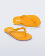Top and angled view a pair of orange Flip Flop Airflow sandal with a clear orange strap and lilac bottom