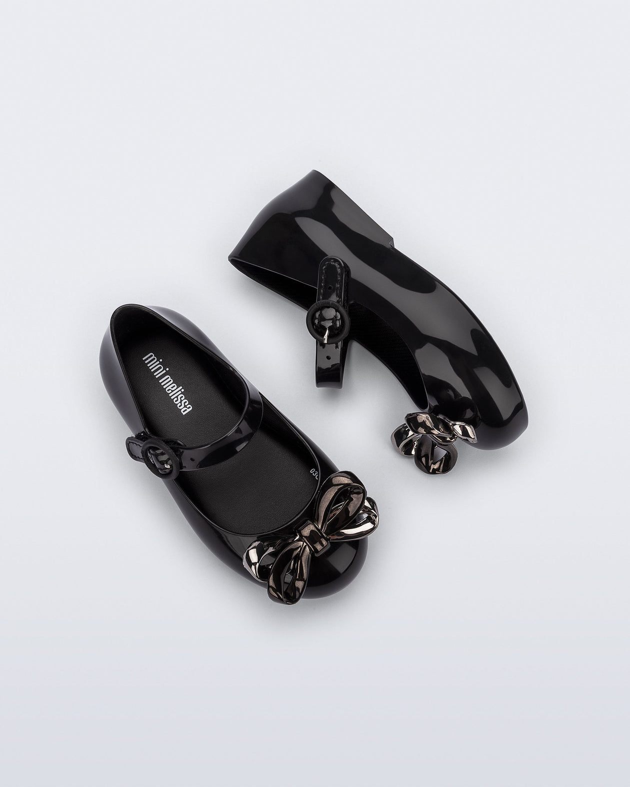 Top and side view of a pair of black Sweet Love Glam baby ballerinas with bow