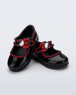 Angled view of a pair of black Hip Ballerina + Hello Kitty baby flats with red trim