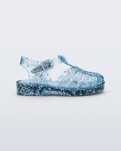 Side view of a blue Possession Elements baby sandal with glitter hearts